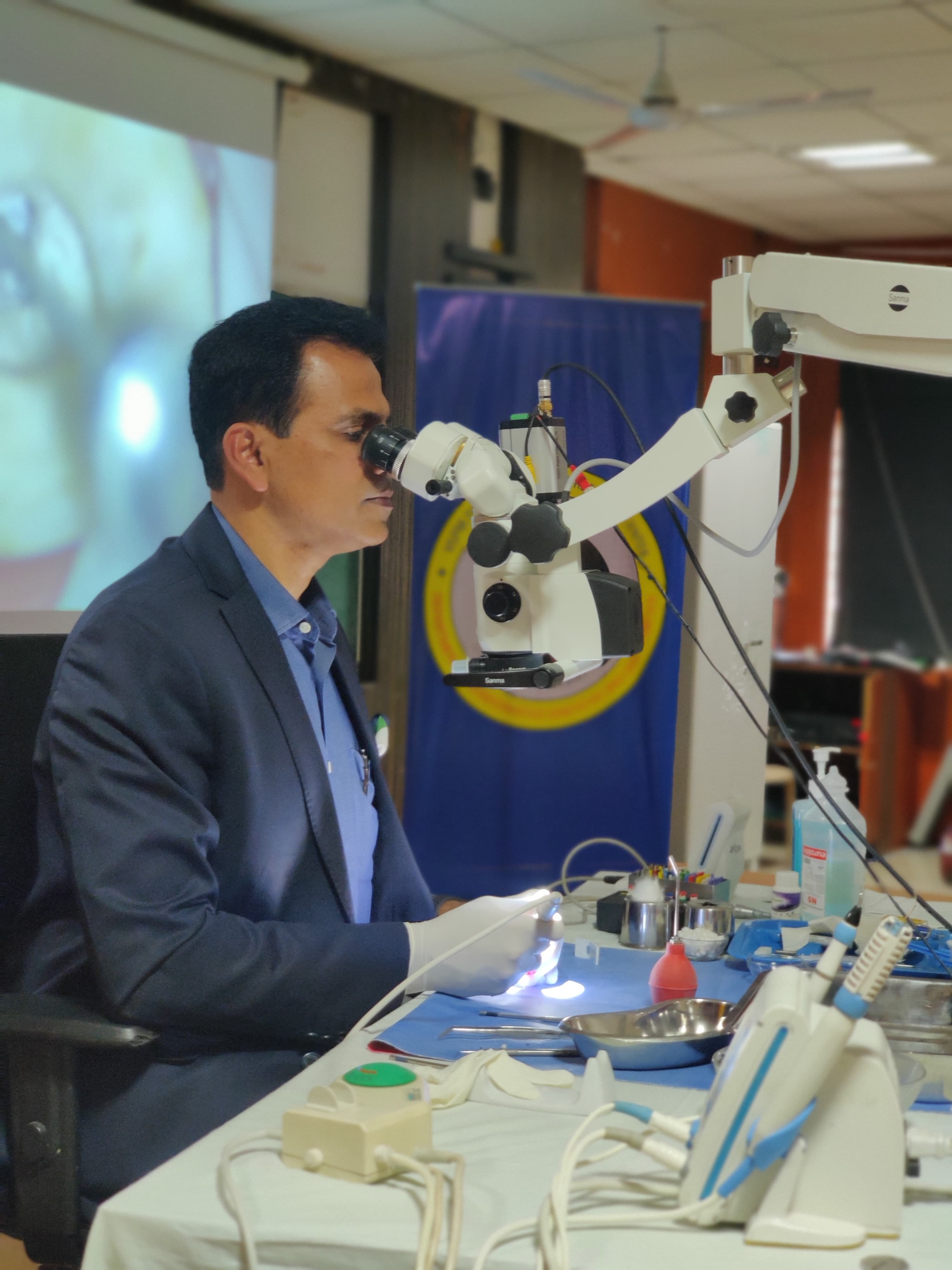 Dental educator demonstrating an endodontic procedure through an operating microscope