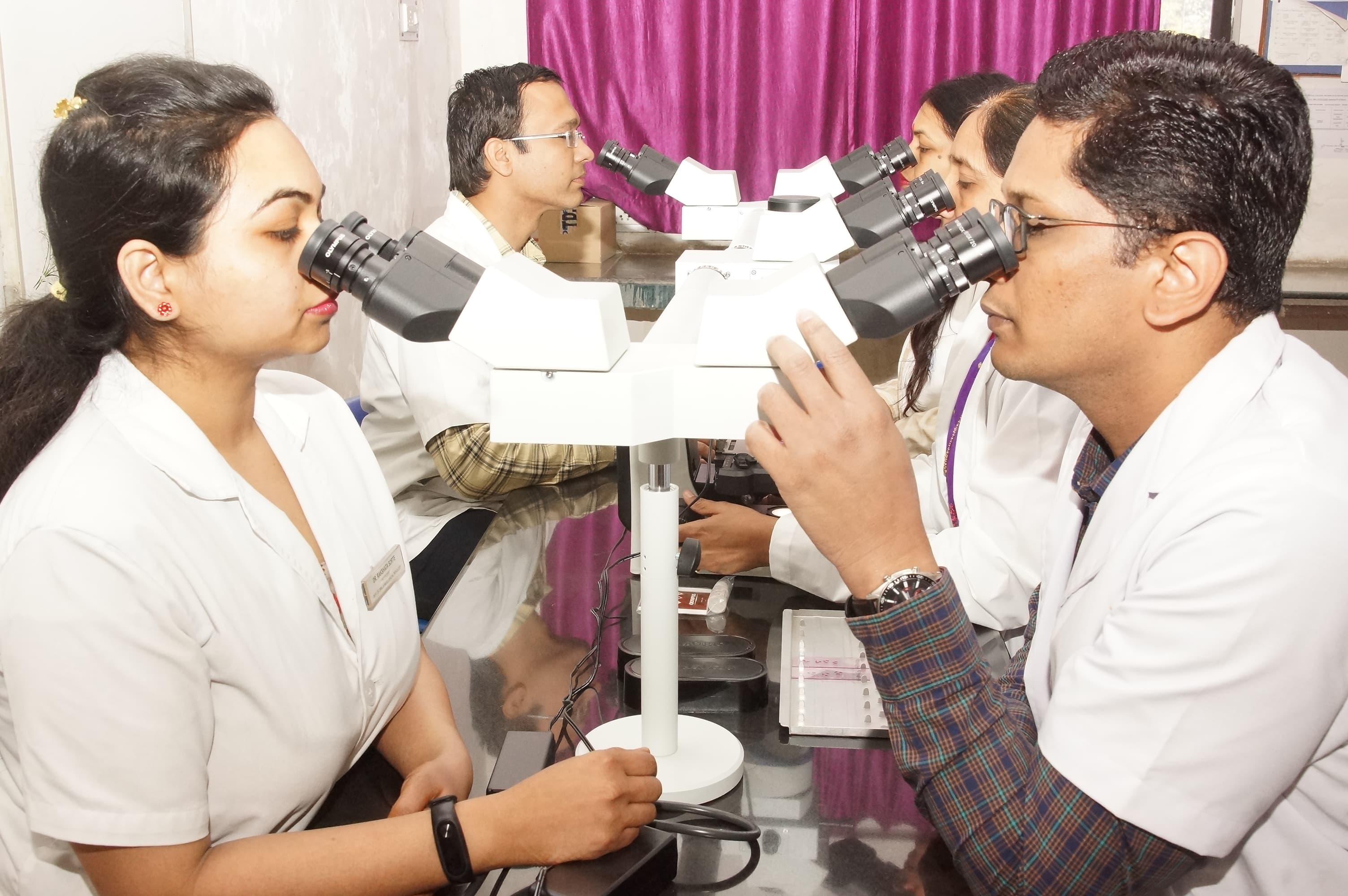 Four health-sciences learners using a multi-view microscope together