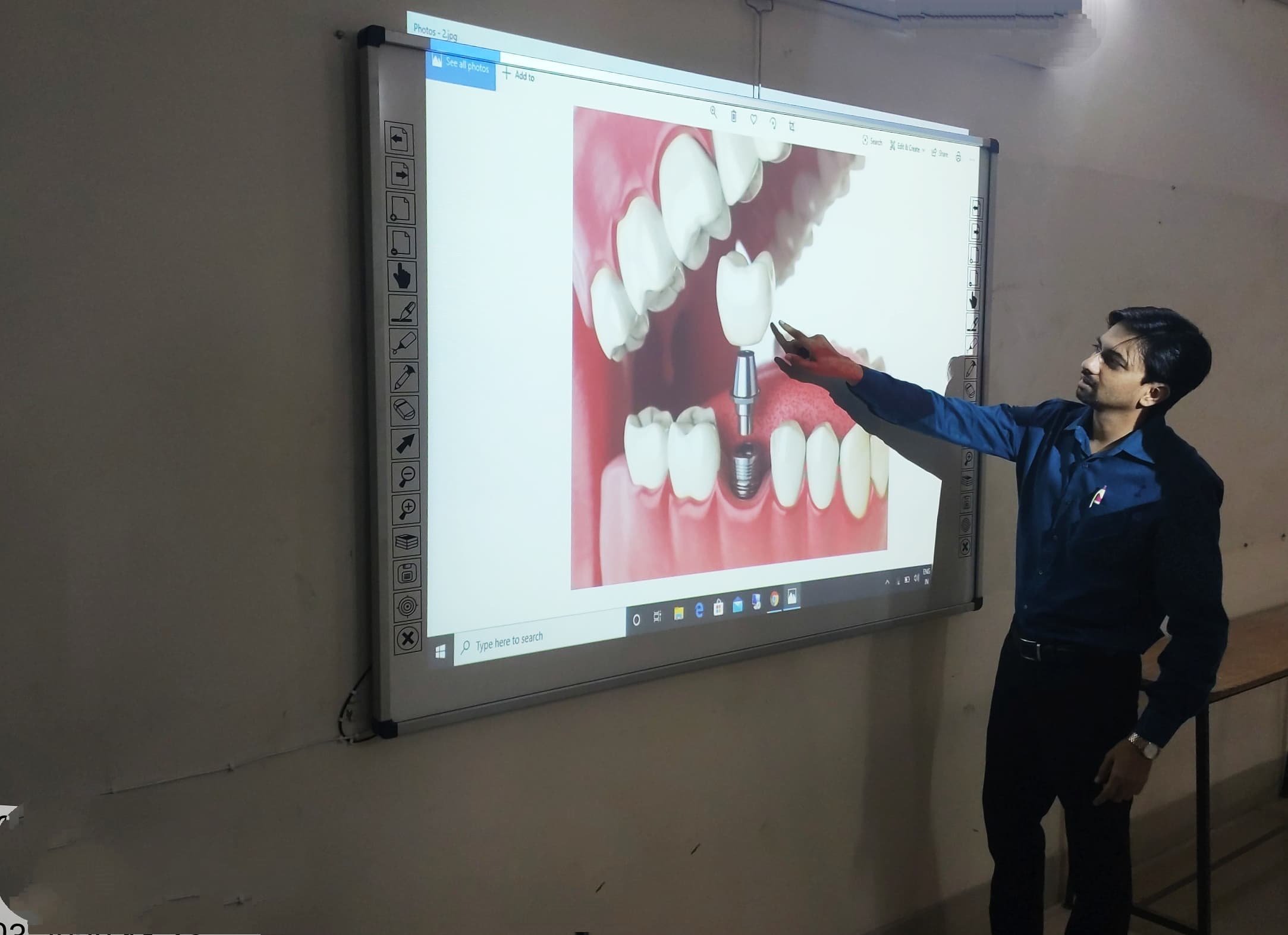 Instructor explaining a dental implant diagram on a large interactive display